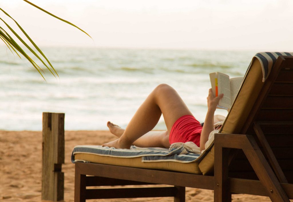 Kobieta na plaży czytająca książkę